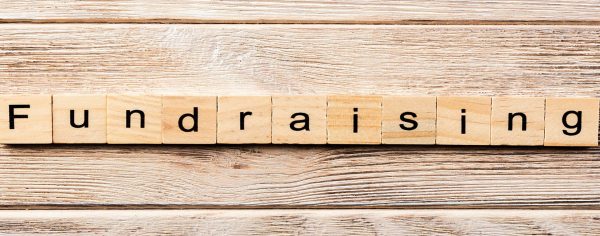 fundraising word written on wood block. fundraising text on table, concept.